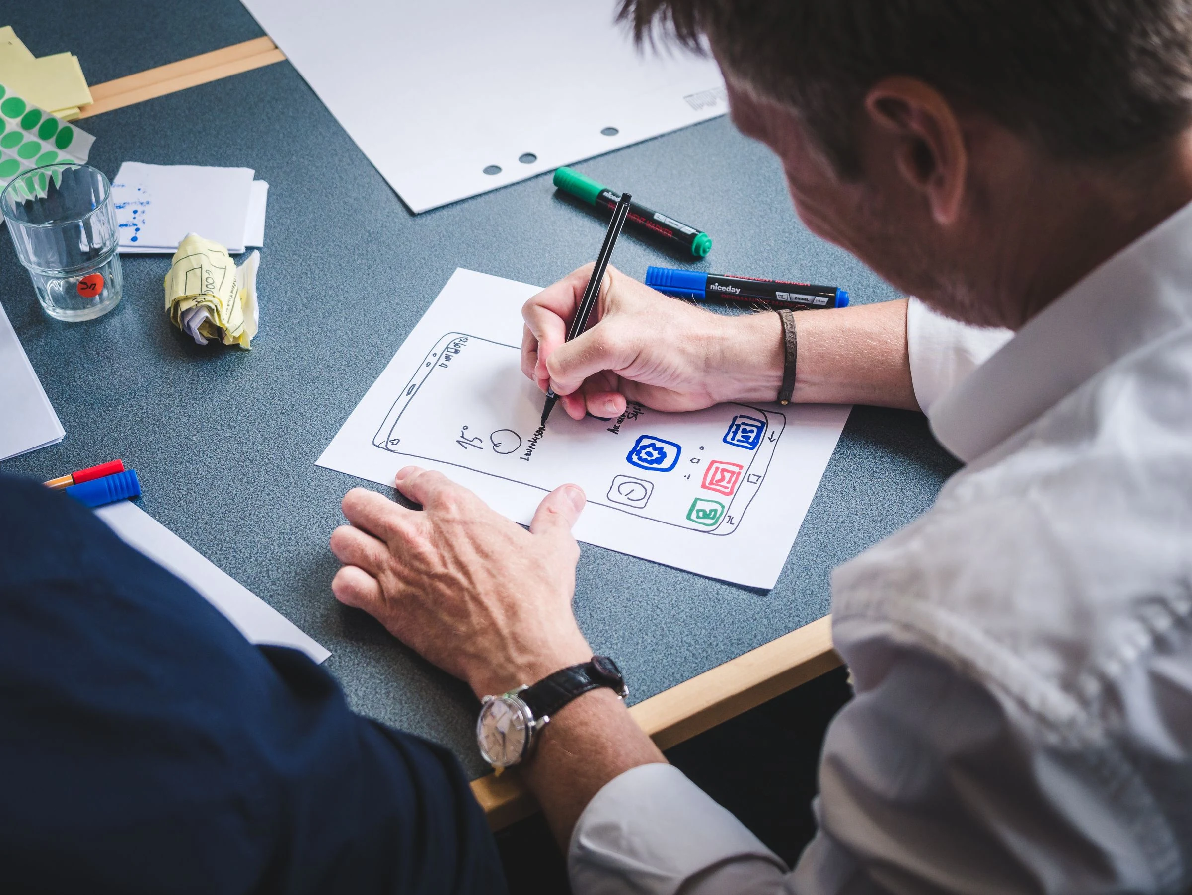 Een ontwerper schetst een app op papier
