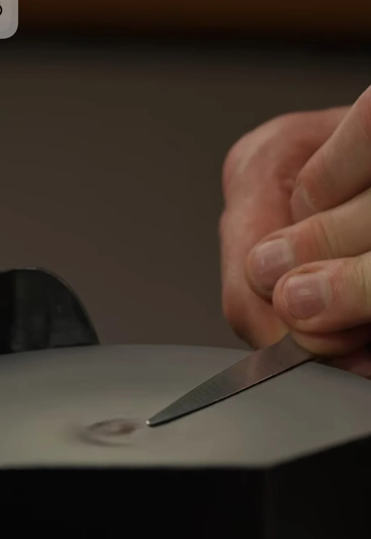 Een kappersschaar wordt met de hand geslepen, de vonken spatten