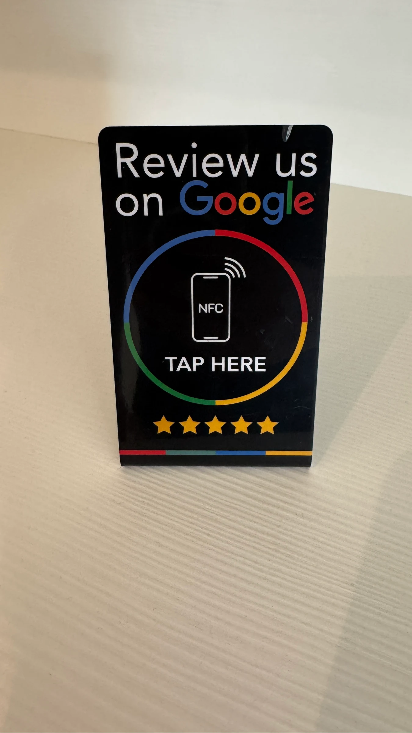 Een NFC-bordje 'Review us on Google' op een tafel