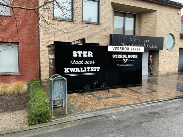 Zwarte versbox 24/24 tegen de gevel van een slagerij