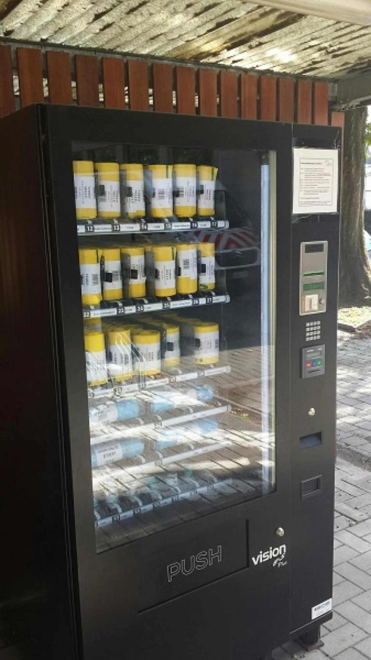 Twee automaten naast elkaar met bekers bovenaan en maaltijden op de lagere schappen