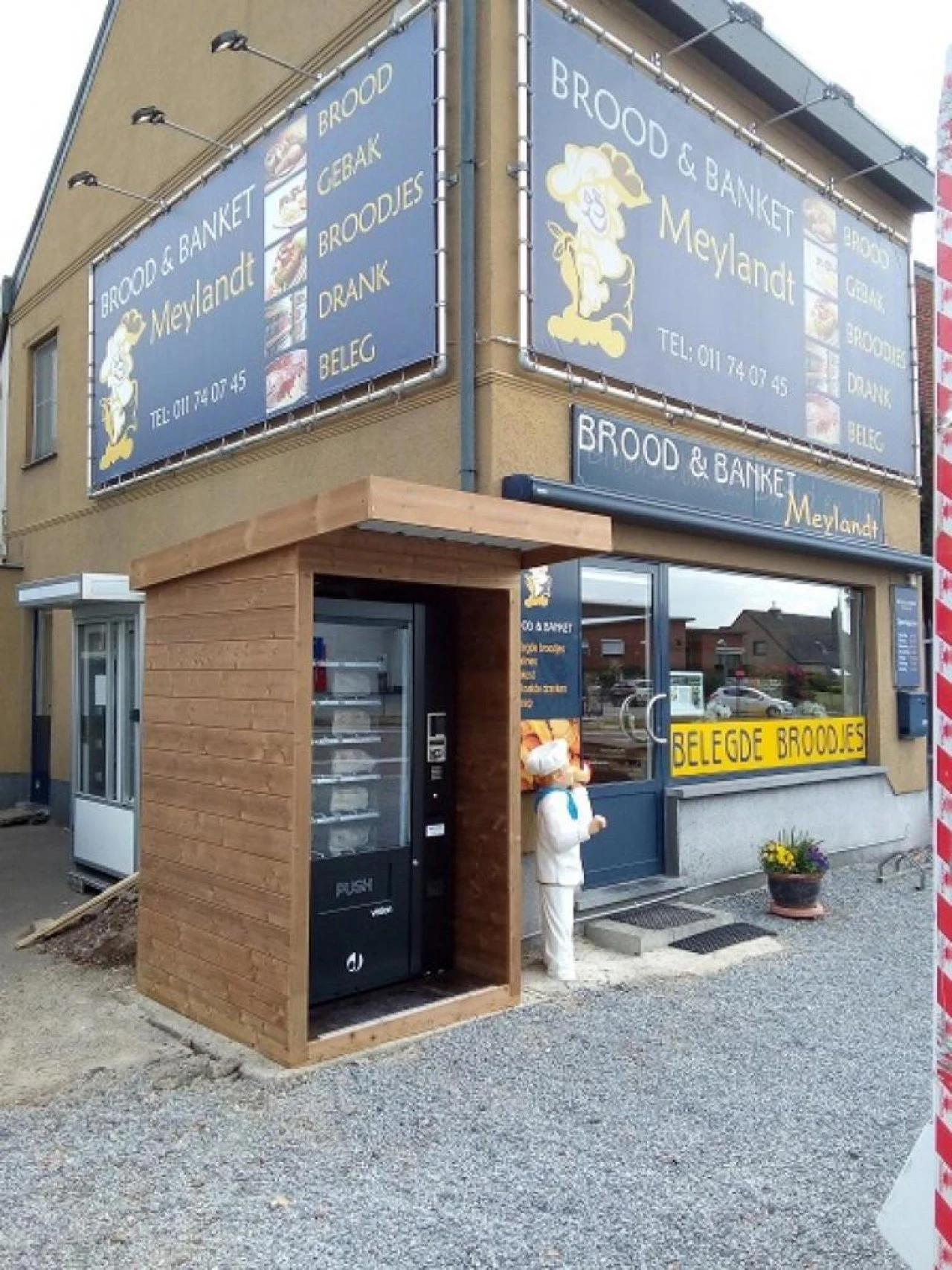 Automaat in een houten kast naast de gevel van bakkerij Brood & Banket Meylandt