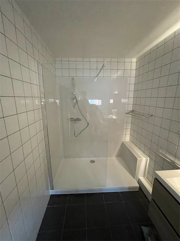 Witte betegelde douche met inloopvlak