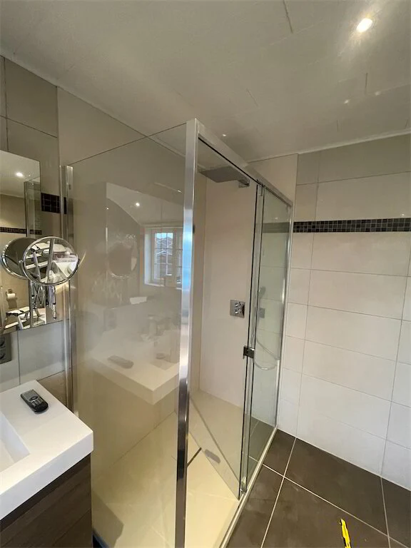 Douche met glazen wand en zwarte kraan